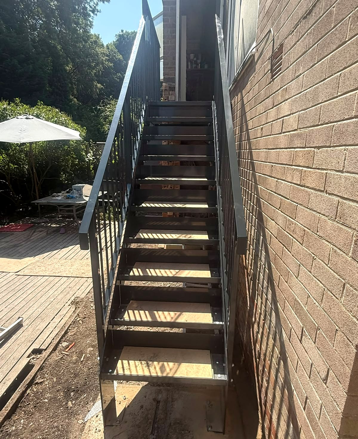 Anthracite grey steel garden access staircase against brickwork, Meadowhead, Sheffield